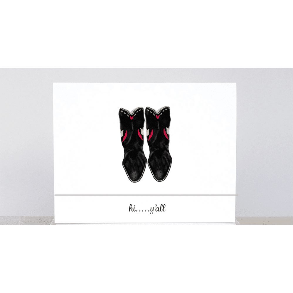 Worn black cowboy boots with the saying 'hi y'all'