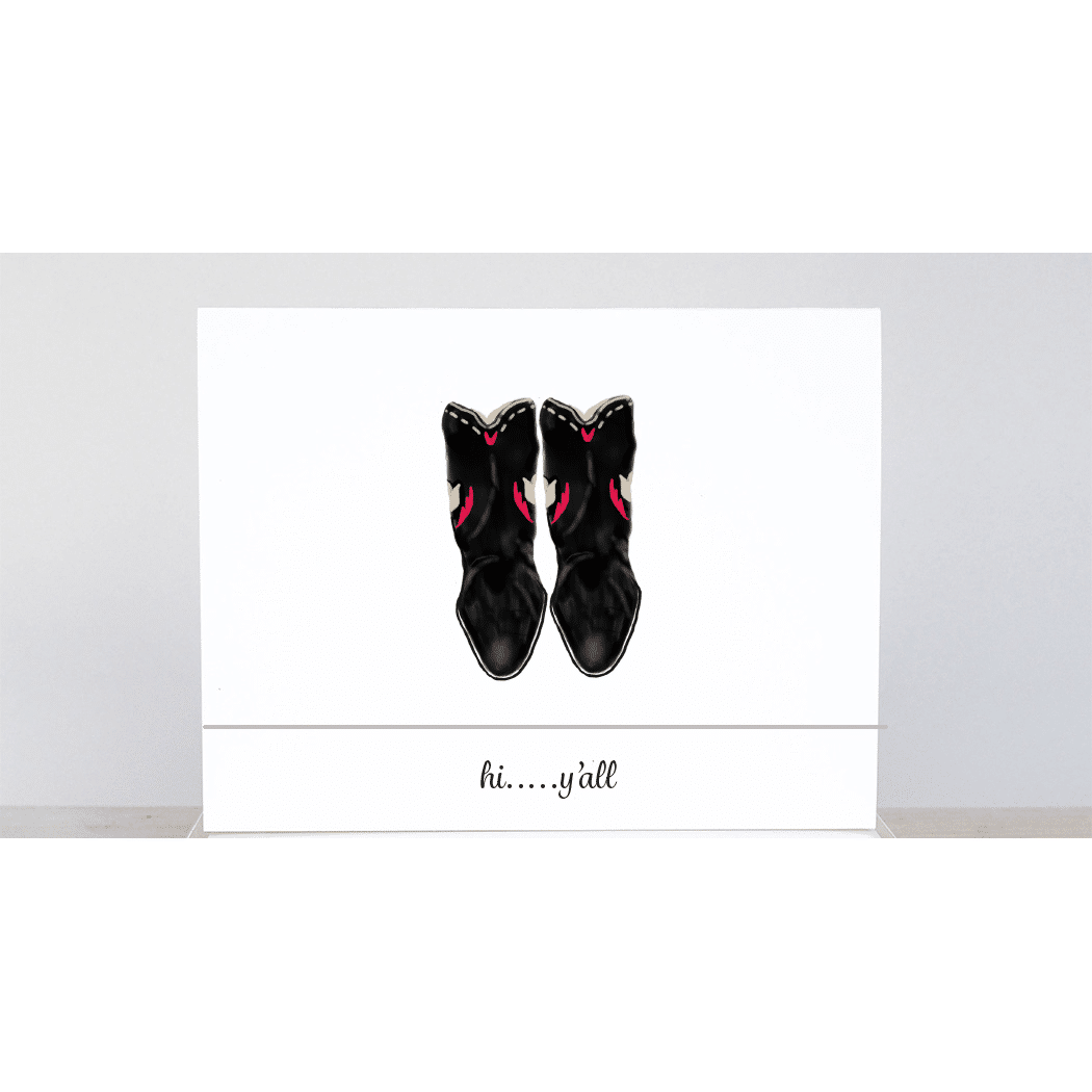 Worn black cowboy boots with the saying 'hi y'all'
